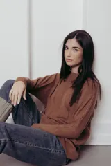 Sweater de punto con textura de ochos verticales, cuello redondo, mangas largas con puños acanalados y silueta relajada.