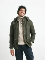 Campera de abrigo color verde militar, con capucha desmontable forrada, cierre frontal con cremallera y botones a presión. Cuenta con múltiples bolsillos: dos en el pecho con cierre, dos en la cintura con botones y un bolsillo en la manga. El interior está forrado para mayor calidez.