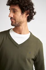 Sweater de tejido de punto en color verde oliva, con escote en V, manga larga y logo bordado en el pecho. Presenta un ajuste regular.