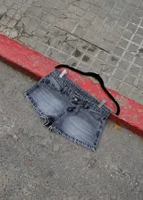 Short de jean negro de tiro bajo, con efecto acid wash y diseño corto ajustado.
