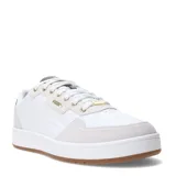 Championes Puma Court Classic Lux SD de estilo urbano inspirado en el tenis. Presentan una silueta de corte bajo en color blanco con detalles en gamuza gris claro en la puntera y el talón, y suela de goma color caramelo. Incluyen el logo de la marca en dorado en el lateral y la lengüeta.