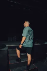 Remerón de manga corta, color gris jaspeado, con estampado grande en la espalda con texto vertical en negro.