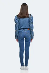 Jean ajustado (skinny) de tiro alto, color azul medio, con efecto levemente desgastado en la parte frontal de los muslos.