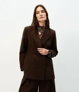 Blazer oversized estructurado marrón de corte cruzado con solapa amplia, bolsillos integrados y cuatro botones frontales.