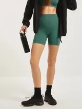 Calza biker de tiro alto, confeccionada en tejido acanalado sin costuras, color verde esmeralda.