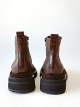 Bota corta de cuero en tonos chocolate, con diseño de paneles texturizados y suela track robusta de goma.