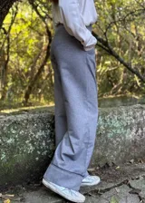 Pantalón gris de corte palazzo con cintura alta y detalle de costuras verticales en el frente.