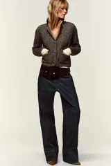 Chaqueta de punto con textura jaspeada, cuello solapa y manga larga. Presenta bolsillos delanteros de plastrón con solapa y cierre frontal con botones forrados a tono.