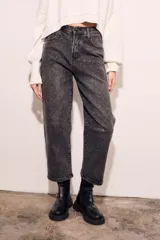 Jean de tiro alto, corte recto y largo al tobillo, en color negro lavado con apliques de strass o brillos distribuidos por toda la prenda.