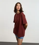 Remera de algodón color marrón óxido, de corte oversized, cuello redondo y manga corta.