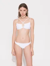 Bikini blanca lisa, con corpiño de breteles cruzados en el delantero y abertura fruncida central, y bombacha vedetina.