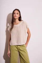 Chaleco sin mangas de tejido de punto color rosado pálido, con textura calada y acabado lurex, corte al cuerpo y cuello redondo.