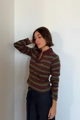 Remera polo de manga larga en tono marrón con rayas horizontales en verde y amarillo mostaza. Cuenta con cuello camisero, escote en V y un pequeño logo bordado en el pecho.