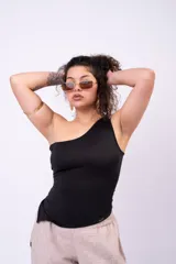 Musculosa negra de un solo hombro, corte al cuerpo y dobladillo inferior asimétrico en punta.