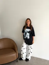 Remeron negro de corte oversize con estampa frontal de gatos. Confeccionado en algodón, presenta cuello redondo y mangas cortas.