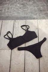 Conjunto de bikini con corpiño estilo bandó alto y breteles regulables, con lazo para atar en la espalda. La bombacha es vedetina con frunce elástico en los costados. Presenta un estampado tipo tie-dye o marmolado en tonos azules y naranjas/terracota.