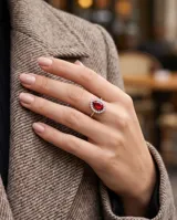 Anillo de plata con piedra central roja en corte gota, rodeada por circonias cúbicas.