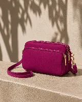 Cartera bandolera fucsia con tres compartimentos principales con cierre, herrajes metálicos dorados y correa ajustable y desmontable.