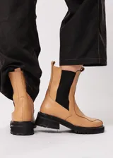 Bota de cuero color camel, estilo Chelsea, con elásticos laterales negros y suela track negra.