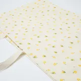Bolso tipo tote bag XXL de tela blanca con estampado de limones y asas dobles.