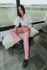 Pantalón de cuero color marrón con estampado abstracto, corte acampanado y abertura en el ruedo.