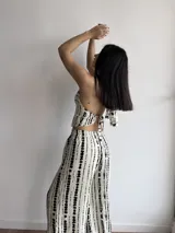 Pantalón de pierna ancha con estampado de rayas verticales negras sobre fondo crudo, confeccionado en tela slab con cintura elástica.