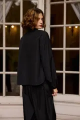 Camisa de nylon color bordó, de corte holgado y diseño minimalista con mangas largas abullonadas y puños elásticos.