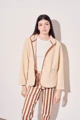 Campera beige de corderito vegano con cuello mao y cierre frontal con botones a presión.