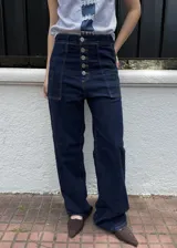 Jean 2 en 1 de color azul oscuro, con corte wide leg transformable a babucha mediante ajuste en los tobillos, tiro alto con cierre frontal de múltiples botones metálicos y bolsillos delanteros destacados.