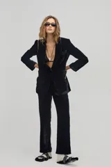 Pantalón de terciopelo negro, de corte recto, tiro medio-alto, pretina con ojales para cinturón, bolsillos laterales y traseros de ojal.