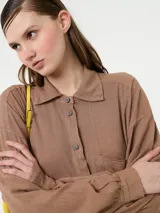 Vestido camisero negro de lino con botones delanteros y bolsillos ocultos.