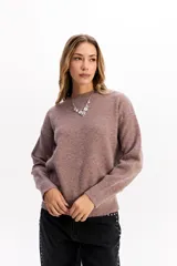 Buzo de punto de textura suave, color malva, con cuello redondo y diseño de calce relajado.