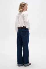 Pantalón de jean azul oscuro, de corte recto y tiro alto, con botamanga rebatida.