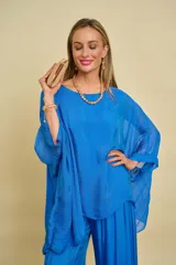 Blusa azul de corte holgado y fluido, con mangas murciélago amplias y escote redondo.