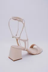 Sandalias negras de cuero con tacón cuadrado y tiras finas para atar al tobillo.