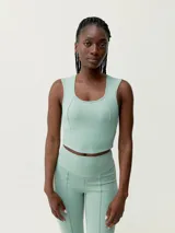 Crop top deportivo verde agua con diseño sobrio y elegante, espalda con pieza de mesh y sujeción media-alta.