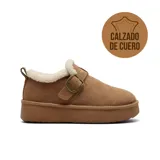 Zapato de cuero tipo zueco con plataforma, forrado internamente con corderito sintético. Presenta una tira ajustable con hebilla metálica en el empeine y un tirador en el talón.