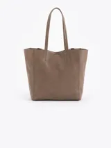 Cartera tipo shopper de cuero vacuno flor graneado, con formato amplio y estructura flexible. Presenta dos cierres verticales decorativos en el frente con tiracierres personalizados y doble manija de hombro.