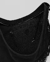 Cartera tipo hobo de gran tamaño en color negro, confeccionada en gamuza con diseño de flecos largos en los laterales y base. Presenta un asa superior trenzada con detalles artesanales y cierre superior para mayor seguridad.