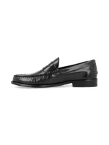 Zapato tipo mocasín de cuero negro con acabado brillante, diseño de antifaz clásico y costuras reforzadas en la puntera.