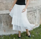 Falda midi en capas plisadas, de color blanco, con cintura elastizada y diseño vaporoso.