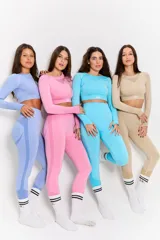 Conjunto deportivo de dos piezas compuesto por un top de manga larga con cuello redondo y detalle de tejido calado en el pecho, y calzas de tiro alto. Ambas prendas presentan un diseño sin costuras en un tono rosado vibrante.