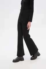 Pantalón de tejido de punto con tiro alto y calce ancho, presentando un estampado pixelado o camuflado en tonos marrón, beige y blanco.