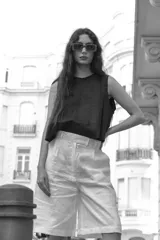 Bermuda blanca de lino, corte sastre, tiro alto, largo a la rodilla y bolsillos laterales.