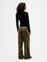 Pantalón de tiro medio y corte recto, confeccionado en terciopelo negro con cintura elástica y bolsillos laterales.