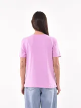 Remera color beige con estampa de texto 'Seaside Florida USA' y dibujo de coral en color lila.