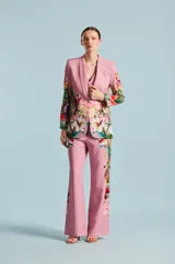 Saco de mujer Natalia Antolin con silueta estructurada, solapa chal y un llamativo estampado floral y botánico en tonos verdes, rojos y blancos sobre base rosada.