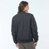 Campera estilo aviador negra, con cierre frontal, cuello redondo y puños y cintura elásticos. Presenta bolsillos de fuelle con doble entrada en la parte inferior y un bolsillo con cierre en la manga izquierda.