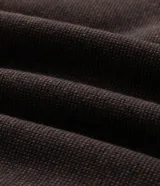 Campera bomber puffer de color marrón oscuro, confeccionada en poliéster con acabado texturizado. Presenta cuello alto, cierre frontal con cremallera, puños y ruedo elásticos.