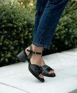 Sandalias de cuero color dorado, con plataforma y taco cuadrado. Presentan tiras cruzadas en el empeine y pulsera al tobillo con hebilla.